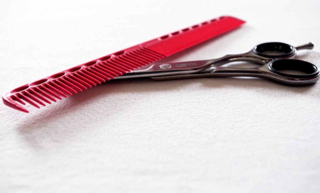 grzebień i nożyczki fryzjerskie na białym tle