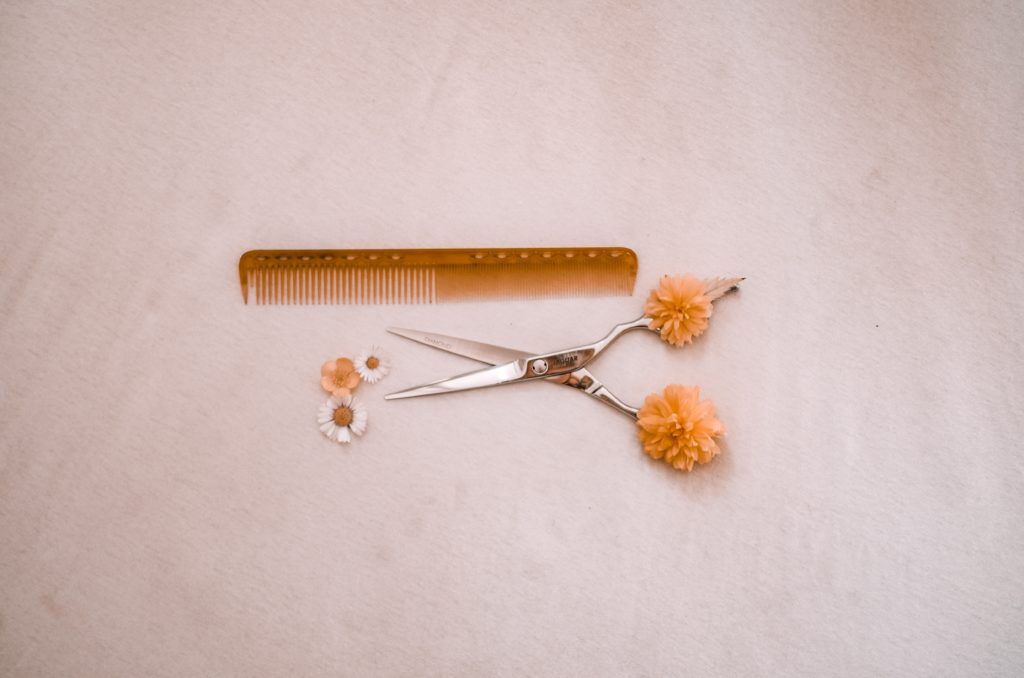 nożyczki fryzjerskie i grzebień wsród kwiatków