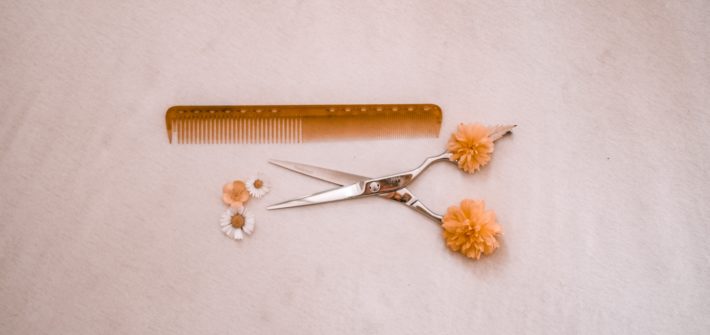 nożyczki fryzjerskie i grzebień wsród kwiatków